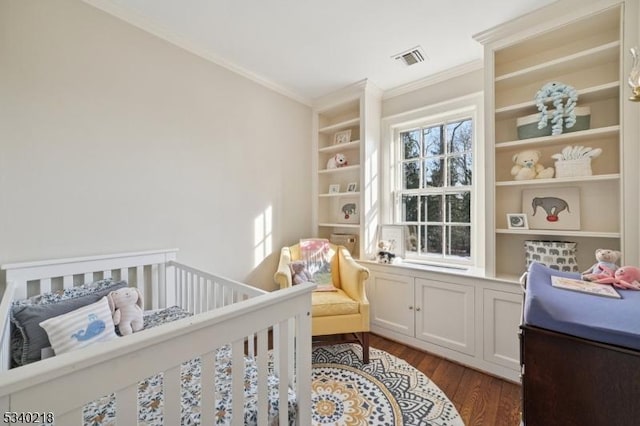 bedroom featuring a crib, dark wood-style floors, visible vents, and ornamental molding