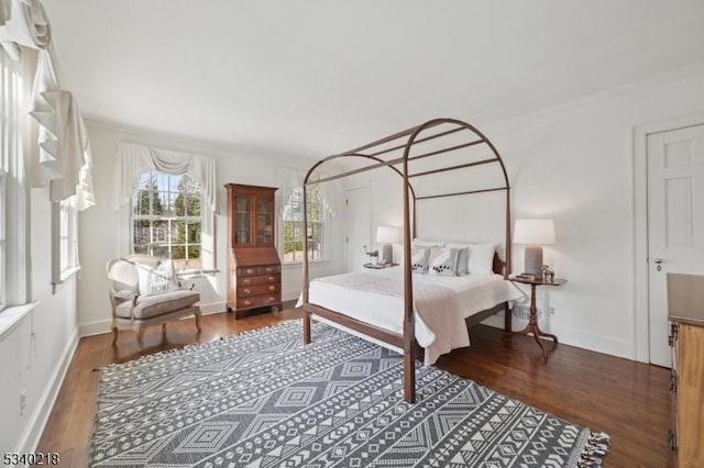 bedroom featuring ornamental molding, dark wood-style flooring, and baseboards