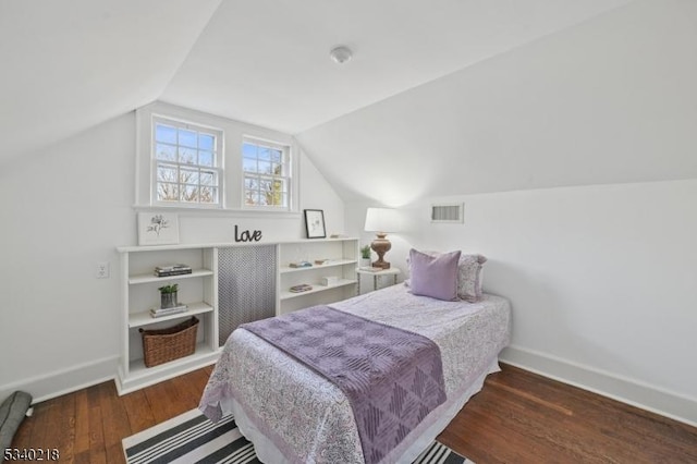 bedroom featuring lofted ceiling, visible vents, dark wood finished floors, and baseboards