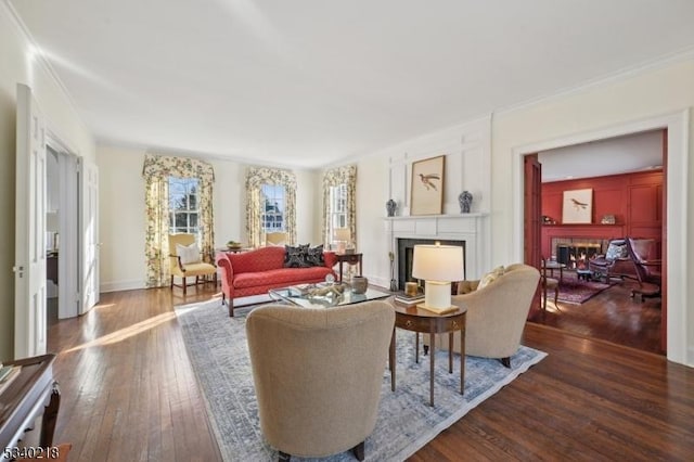 living room with a fireplace, baseboards, dark wood-style flooring, and ornamental molding