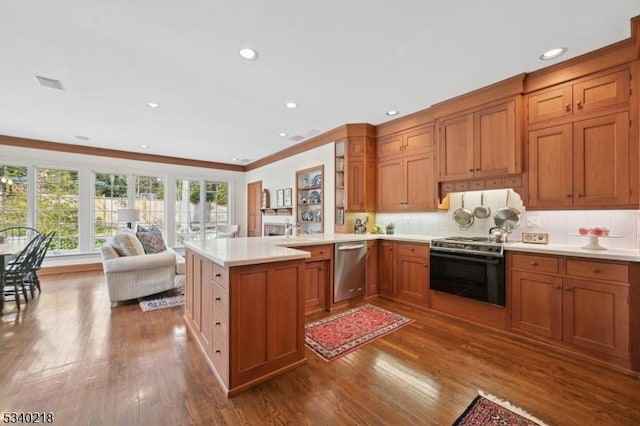 kitchen featuring dishwasher, stove, brown cabinets, open floor plan, and light countertops