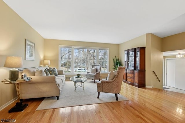 living area with baseboards and wood finished floors