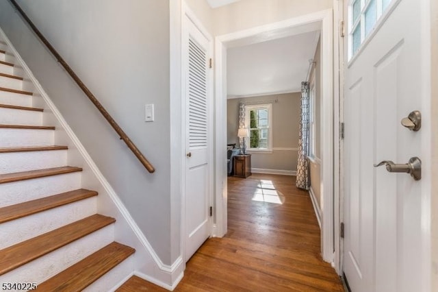 entryway with stairway, baseboards, and wood finished floors