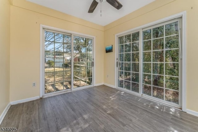 doorway to outside featuring a ceiling fan, baseboards, and wood finished floors