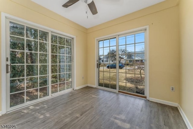 spare room featuring ceiling fan, baseboards, and wood finished floors