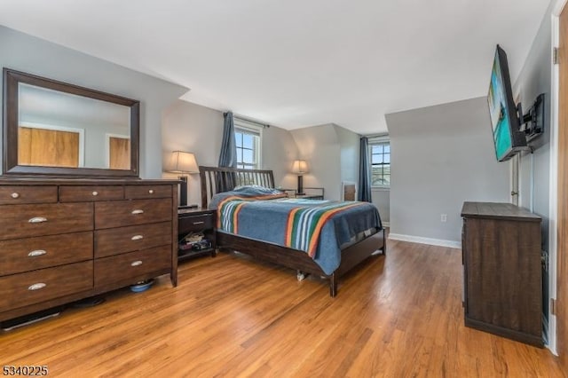 bedroom with light wood-style flooring and baseboards