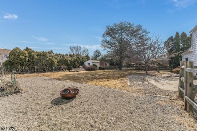 view of yard featuring fence and a fire pit