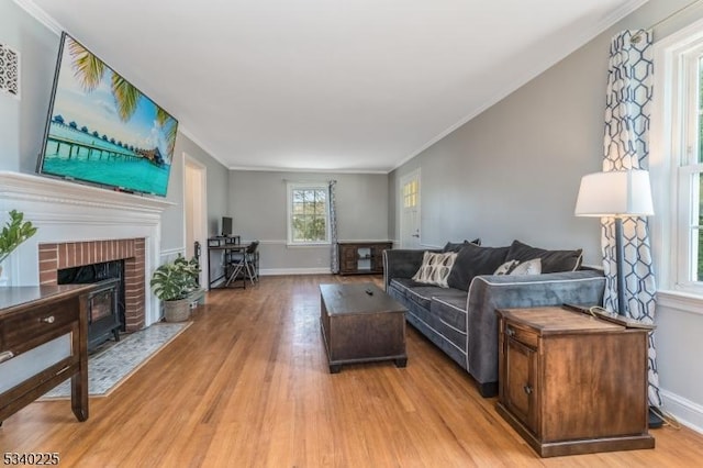 living room with light wood-type flooring, crown molding, and baseboards