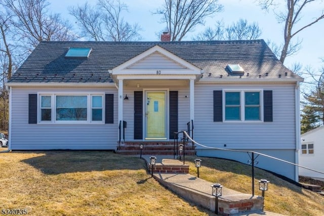 view of front facade featuring entry steps, a front lawn, and a chimney