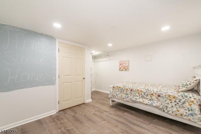 bedroom with baseboards, wood finished floors, and recessed lighting