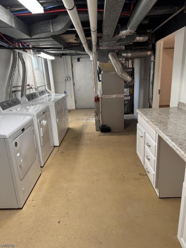 unfinished below grade area featuring heating unit and washing machine and dryer