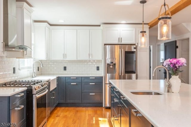 kitchen featuring stainless steel appliances, light countertops, white cabinets, and a sink