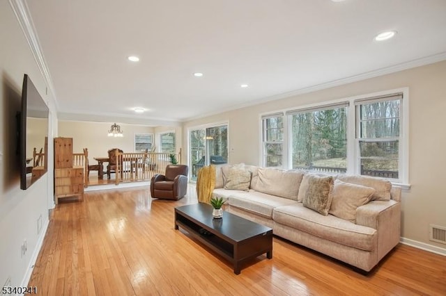 living room with baseboards, light wood-style floors, recessed lighting, and crown molding