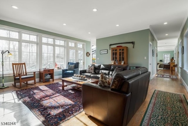 living area with baseboards, light wood-type flooring, and recessed lighting