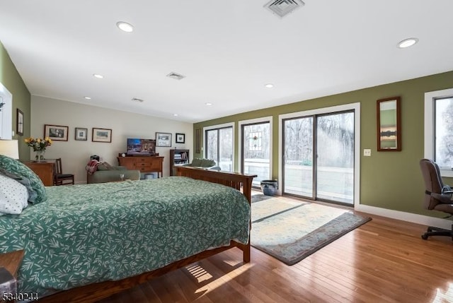 bedroom with baseboards, visible vents, wood finished floors, access to outside, and recessed lighting