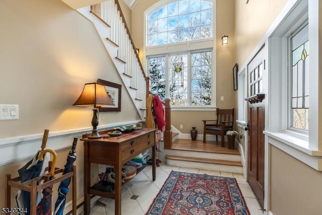 interior space with stairs, a high ceiling, and light tile patterned floors