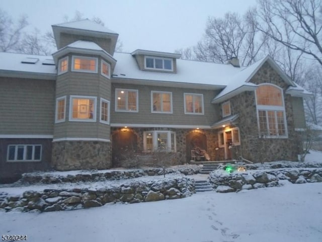 shingle-style home featuring stone siding