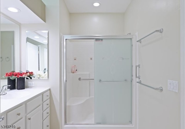 bathroom featuring recessed lighting, a shower stall, and vanity