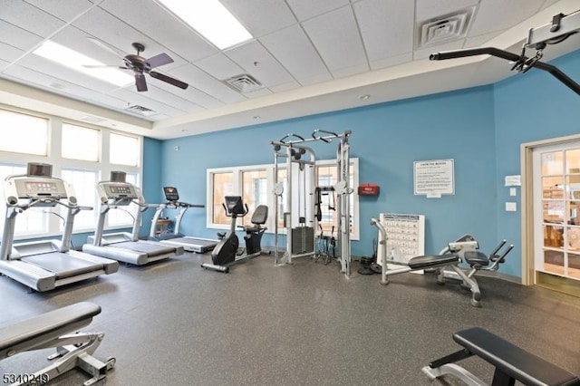 gym with a paneled ceiling, visible vents, and plenty of natural light