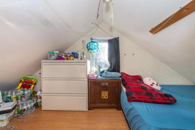 bedroom with lofted ceiling and light wood finished floors