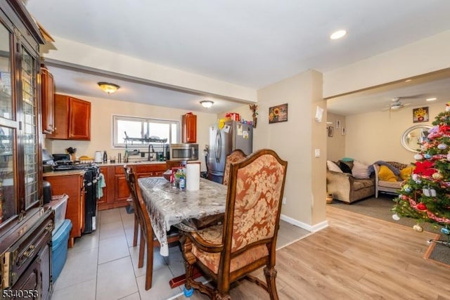 dining area featuring light wood-style flooring and baseboards