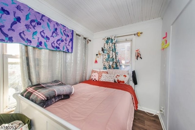 bedroom featuring ornamental molding, dark wood finished floors, and baseboards