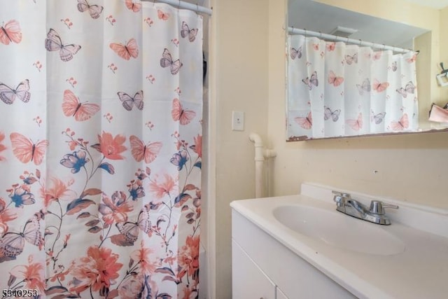 bathroom with curtained shower and vanity