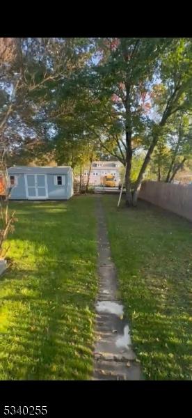 view of yard featuring a storage unit and an outbuilding