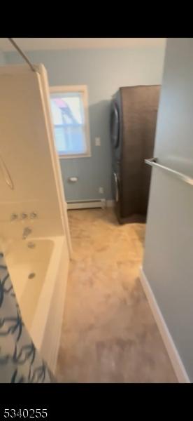 interior space featuring a baseboard radiator, baseboards, and shower / tub combination