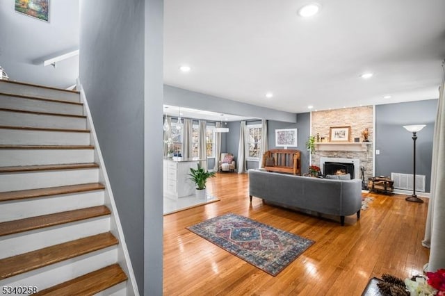 living area featuring visible vents, hardwood / wood-style flooring, recessed lighting, a fireplace, and stairs