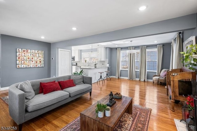 living room with a wealth of natural light, recessed lighting, baseboards, and light wood finished floors