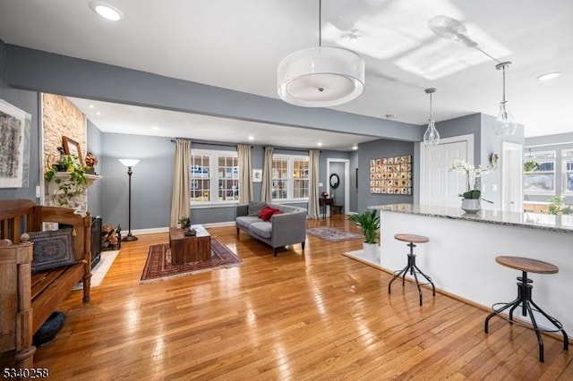 living area with plenty of natural light, recessed lighting, and light wood-style floors