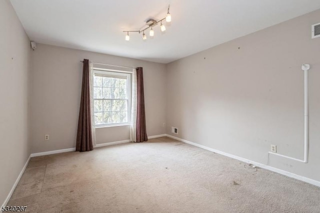 unfurnished room featuring light carpet, visible vents, and baseboards