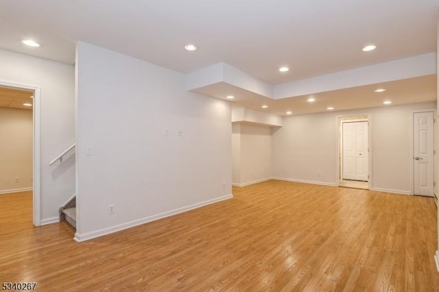 spare room with light wood finished floors, baseboards, stairway, and recessed lighting