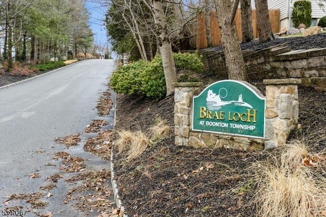 community sign featuring aphalt driveway