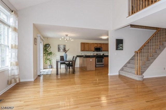 interior space featuring stairs, light wood finished floors, and an inviting chandelier