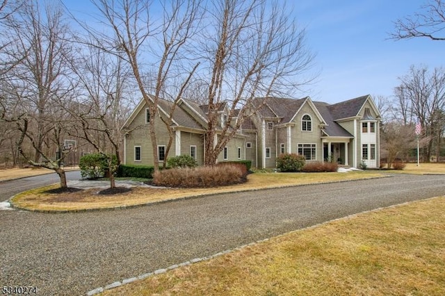 shingle-style home featuring a front lawn