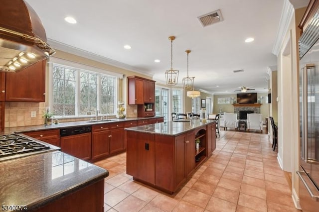 kitchen with open floor plan, visible vents, crown molding, and wall chimney range hood