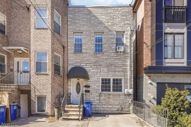 view of front facade with entry steps, stone siding, and brick siding