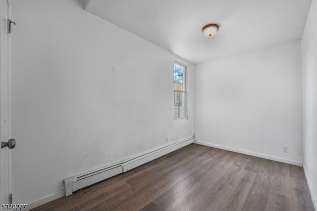 unfurnished room with a baseboard radiator, wood finished floors, and baseboards