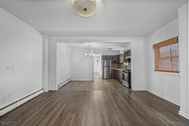 unfurnished living room featuring dark wood-type flooring, baseboards, a notable chandelier, and baseboard heating