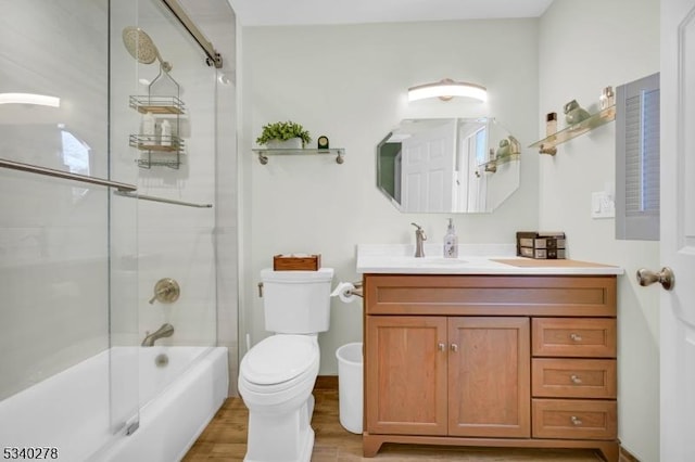 bathroom with wood finished floors, shower / washtub combination, vanity, and toilet