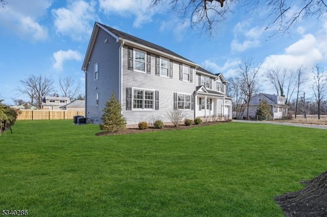 exterior space with fence, central AC, and a front yard