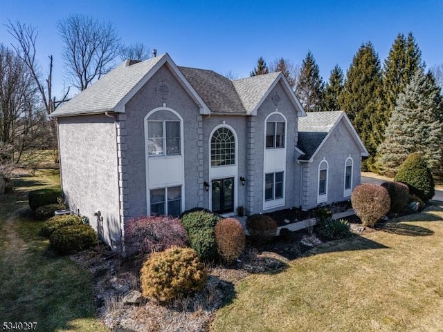 view of front of house featuring french doors, a shingled roof, and a front yard