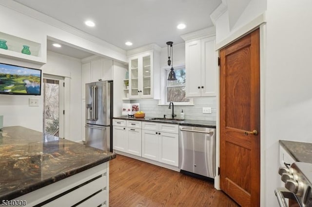 kitchen with dark wood-style floors, white cabinetry, stainless steel appliances, and a sink