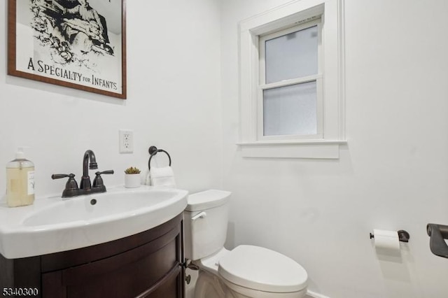 half bathroom with vanity and toilet