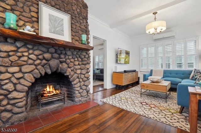 living room with ornamental molding, an AC wall unit, a stone fireplace, and wood finished floors