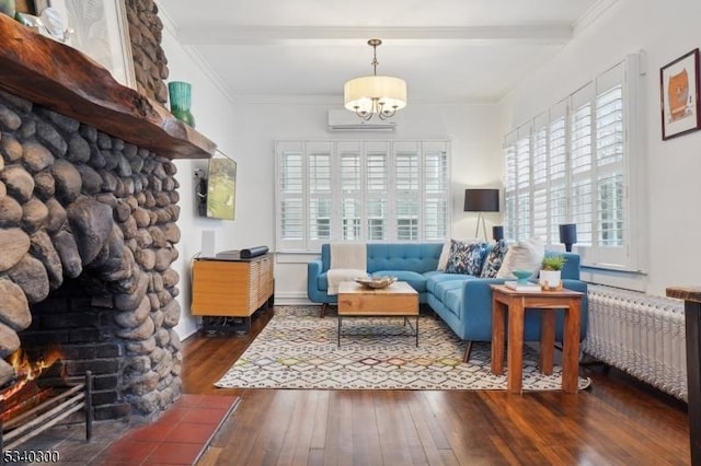 living area with a stone fireplace, a wall unit AC, hardwood / wood-style flooring, radiator heating unit, and crown molding