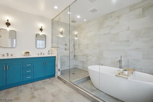 bathroom featuring double vanity, a sink, a freestanding tub, a shower stall, and tile walls