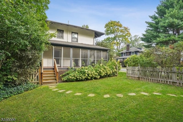 view of yard with a sunroom and fence